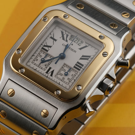 A Cartier watch with a silver-toned stainless steel case and bracelet, a gold-toned bezel, and a white dial with Roman numerals, set against a yellow background.