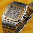 A Cartier watch with a silver-toned stainless steel case and bracelet, a gold-toned bezel, and a white dial with Roman numerals, set against a yellow background.