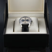 A TAG Heuer Carrera 18 Telemeter wristwatch with a silver-toned stainless steel case, a champagne dial, black subdials, and a black leather strap, shown in a close-up shot.